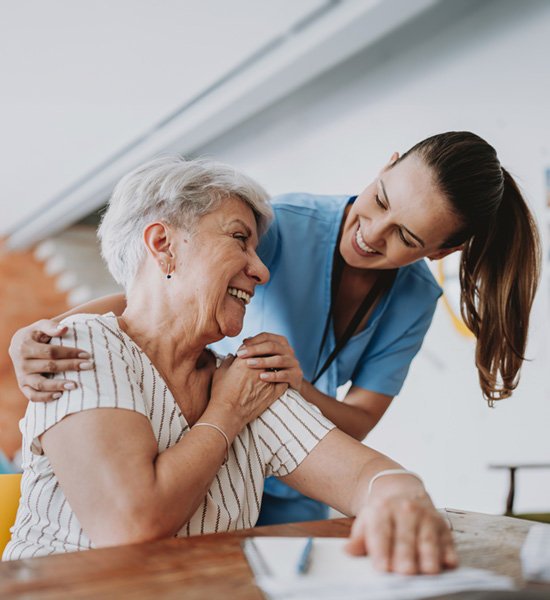 Home care healthcare professional hugging senior patient